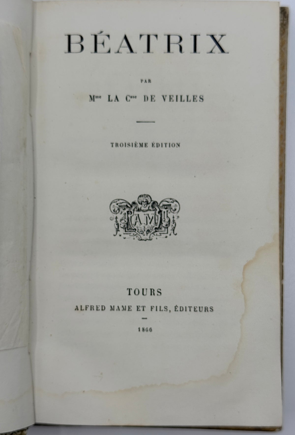An open vintage book showing the title page for 'BÉATRIX' by 'Mme la Cte de Veilles', with printed black text on aged off-white paper and a visible publisher mark for Tours, Alfred Name et Fils, 1866.