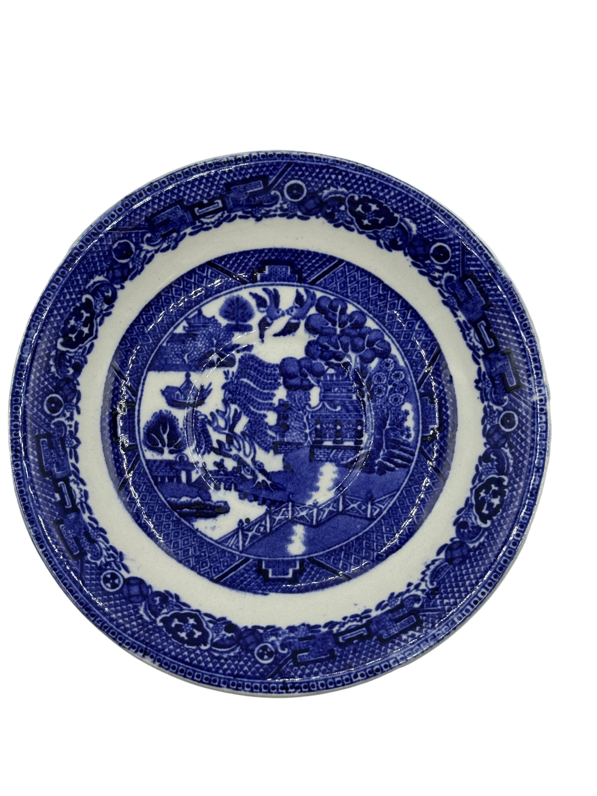 A round ceramic plate with a blue and white transfer print featuring a central figure and decorative border details, shown against a plain light background.