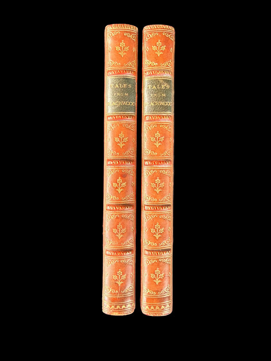Two ornate books with decorative spines on a dark gray background