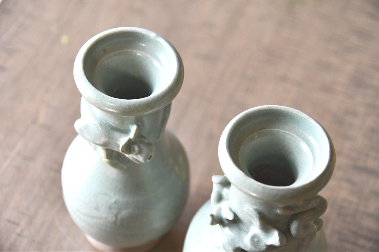 Two ceramic vases on a wooden surface