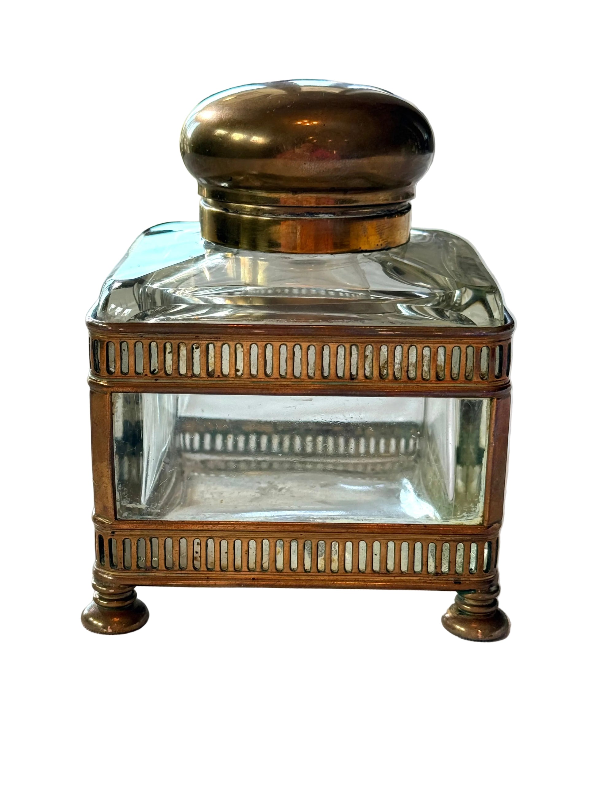 Vintage inkwell with brass base and lid on a white surface