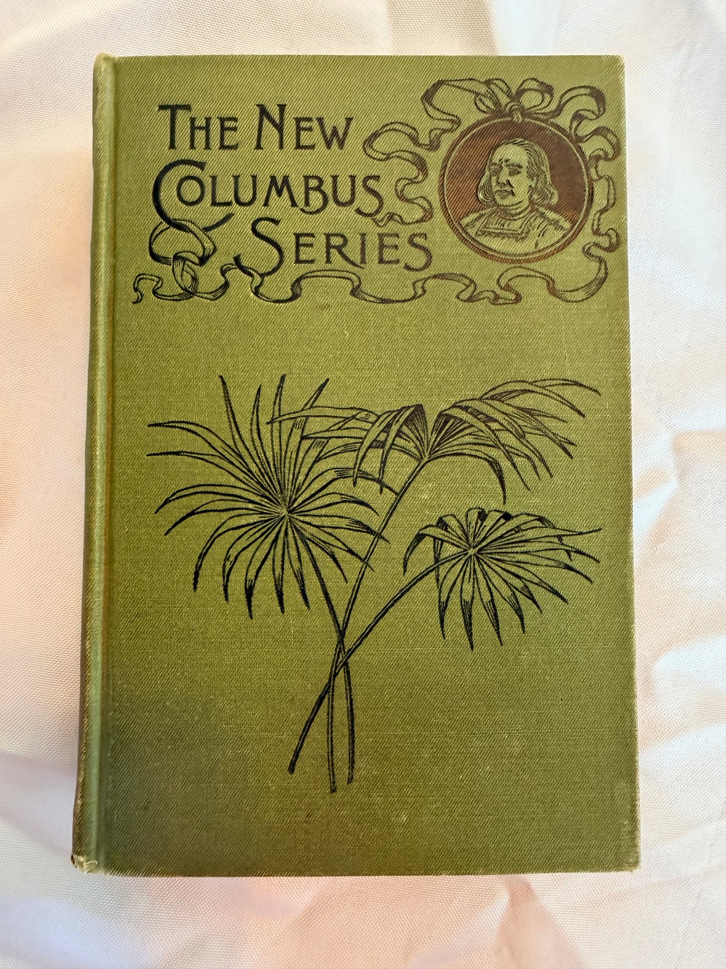 Vintage book titled 'The New Columbus Series' with botanical illustration on a soft pink background