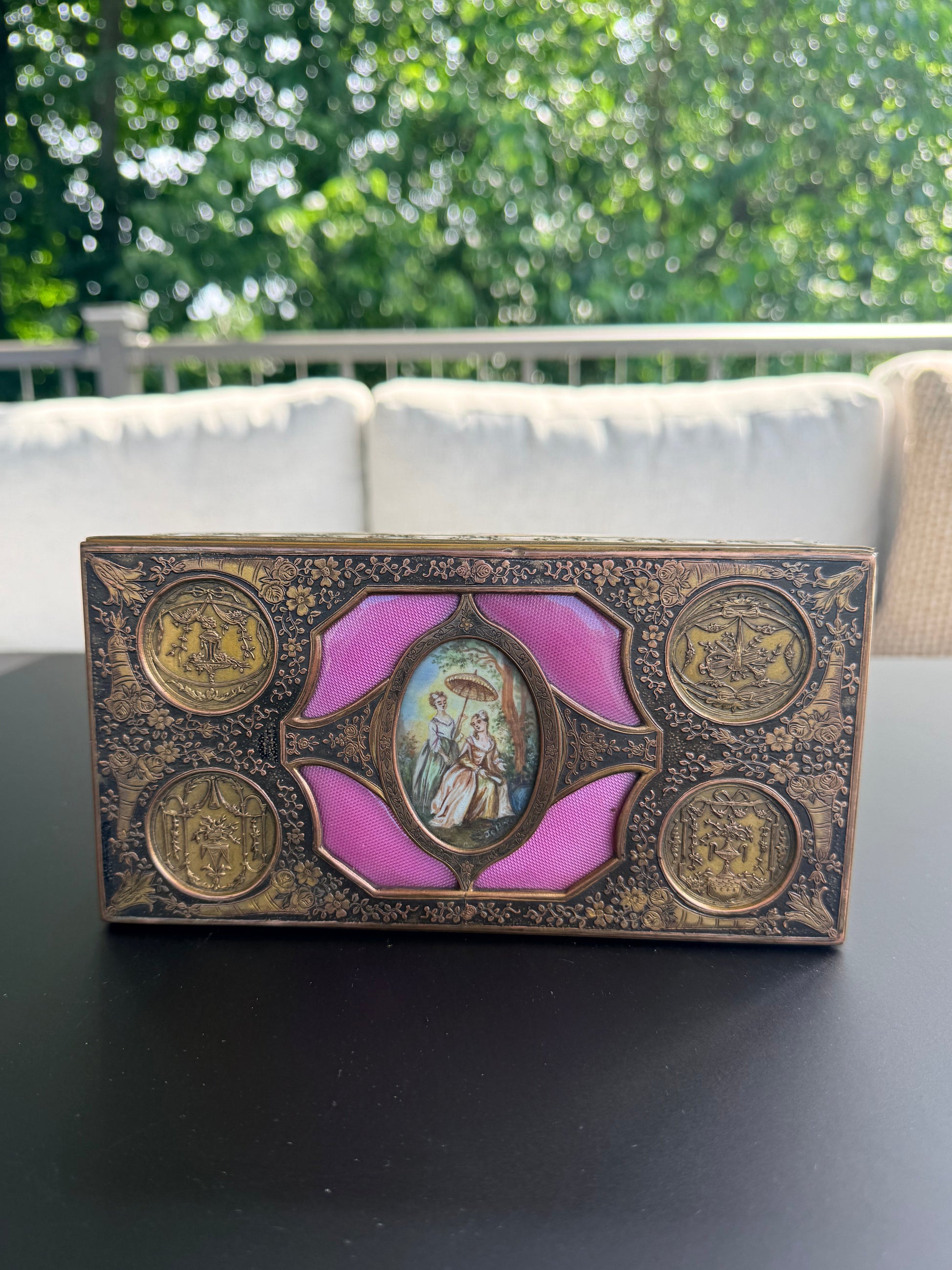 Decorative box with purple center and gold accents on a gray surface