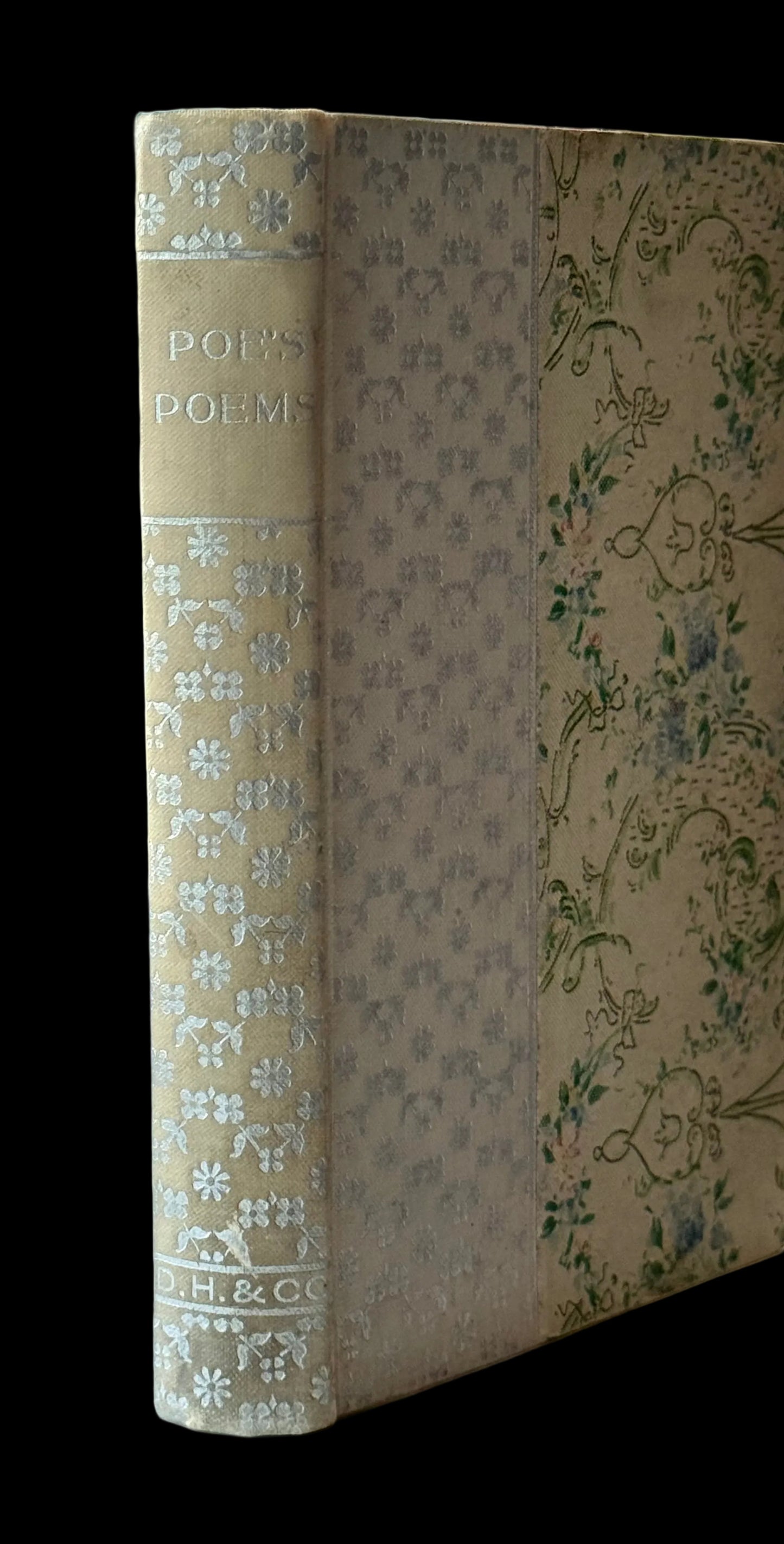 Vintage book with floral design on a white surface near a window
