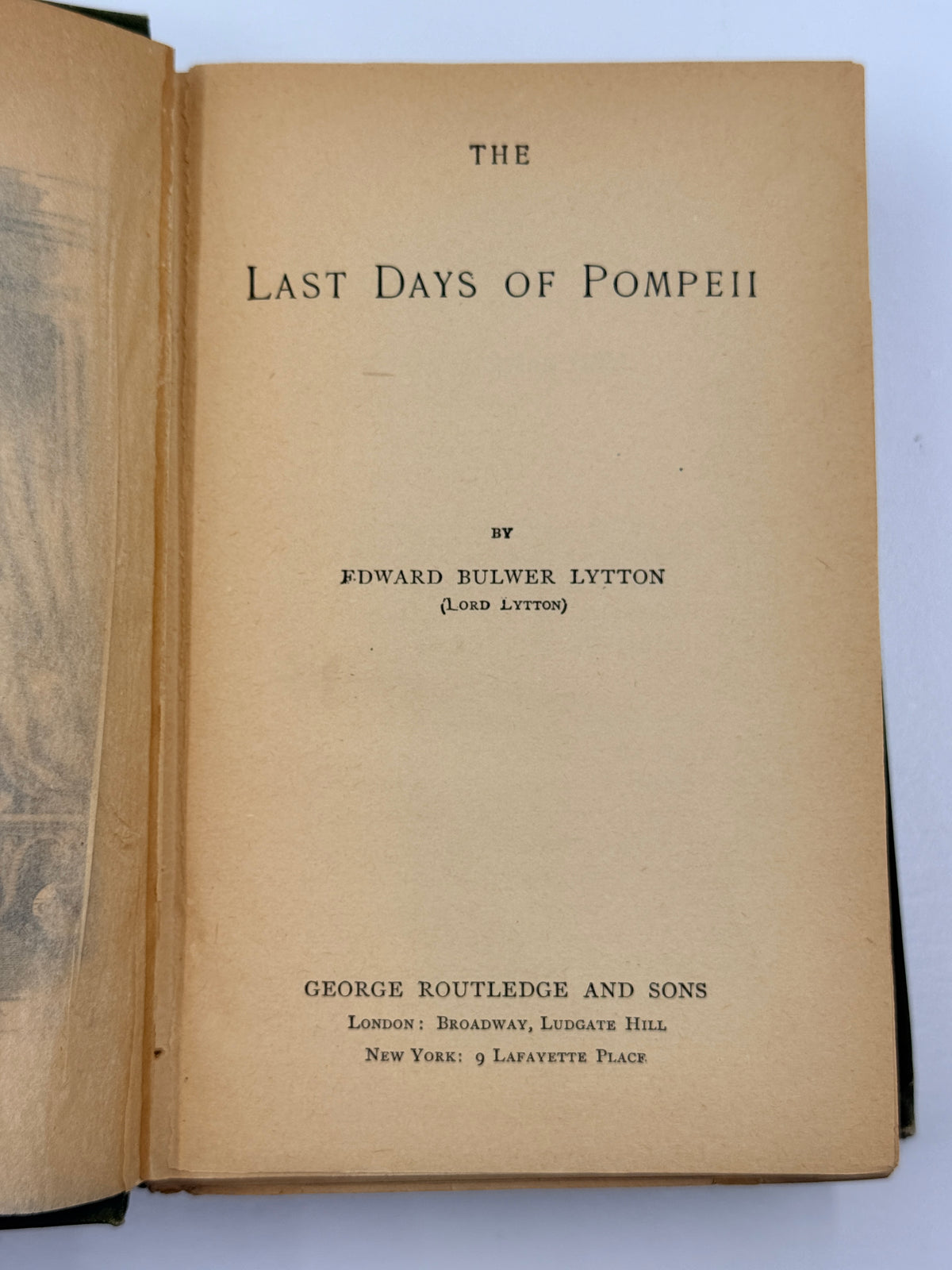 An open vintage book showing the title page for 'The Last Days of Pompeii' by Edward Bulwer Lyttton, with aged tan paper and black printed text.