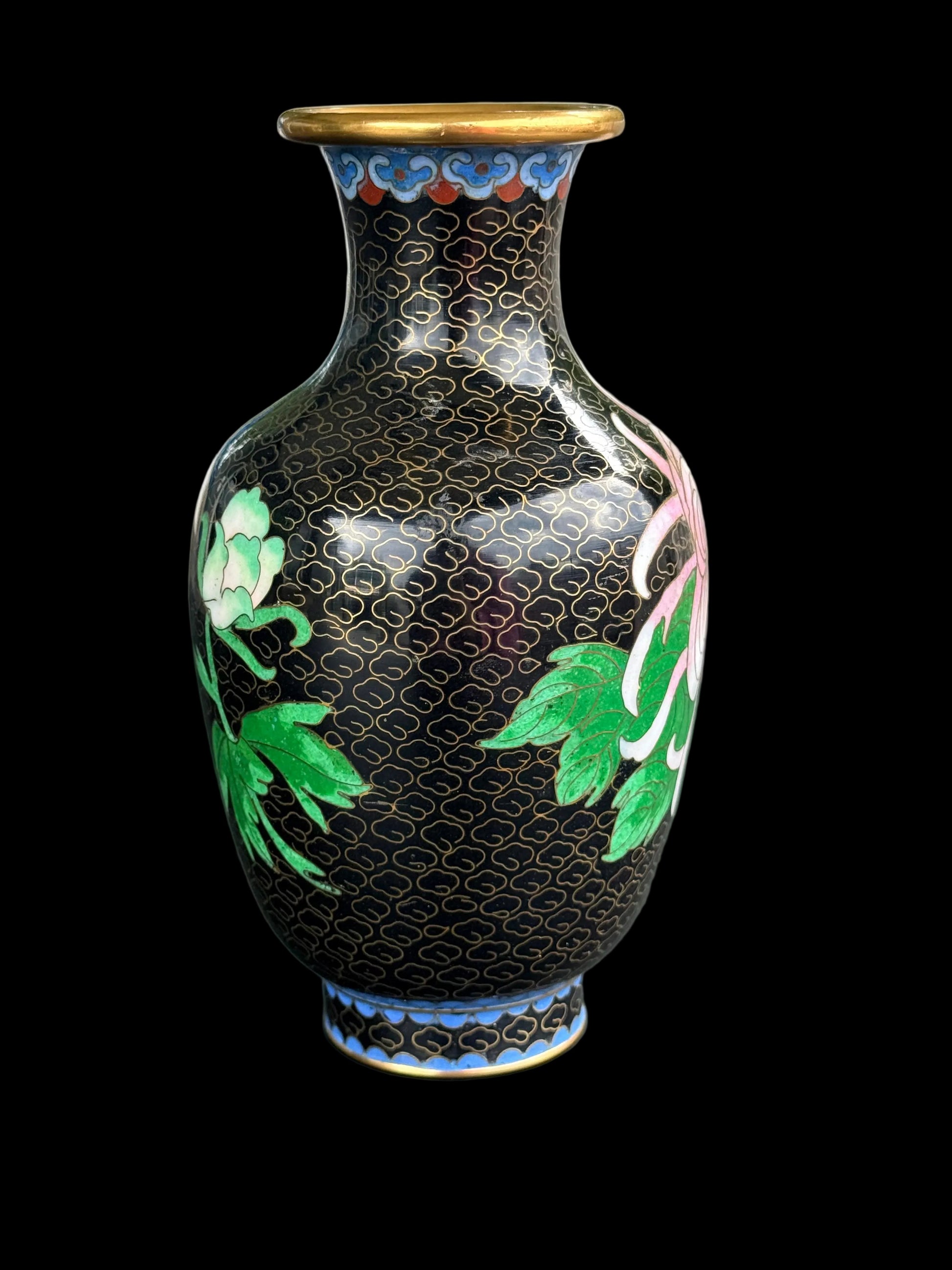 Decorative vase with floral patterns on a mannequin against a blurred background