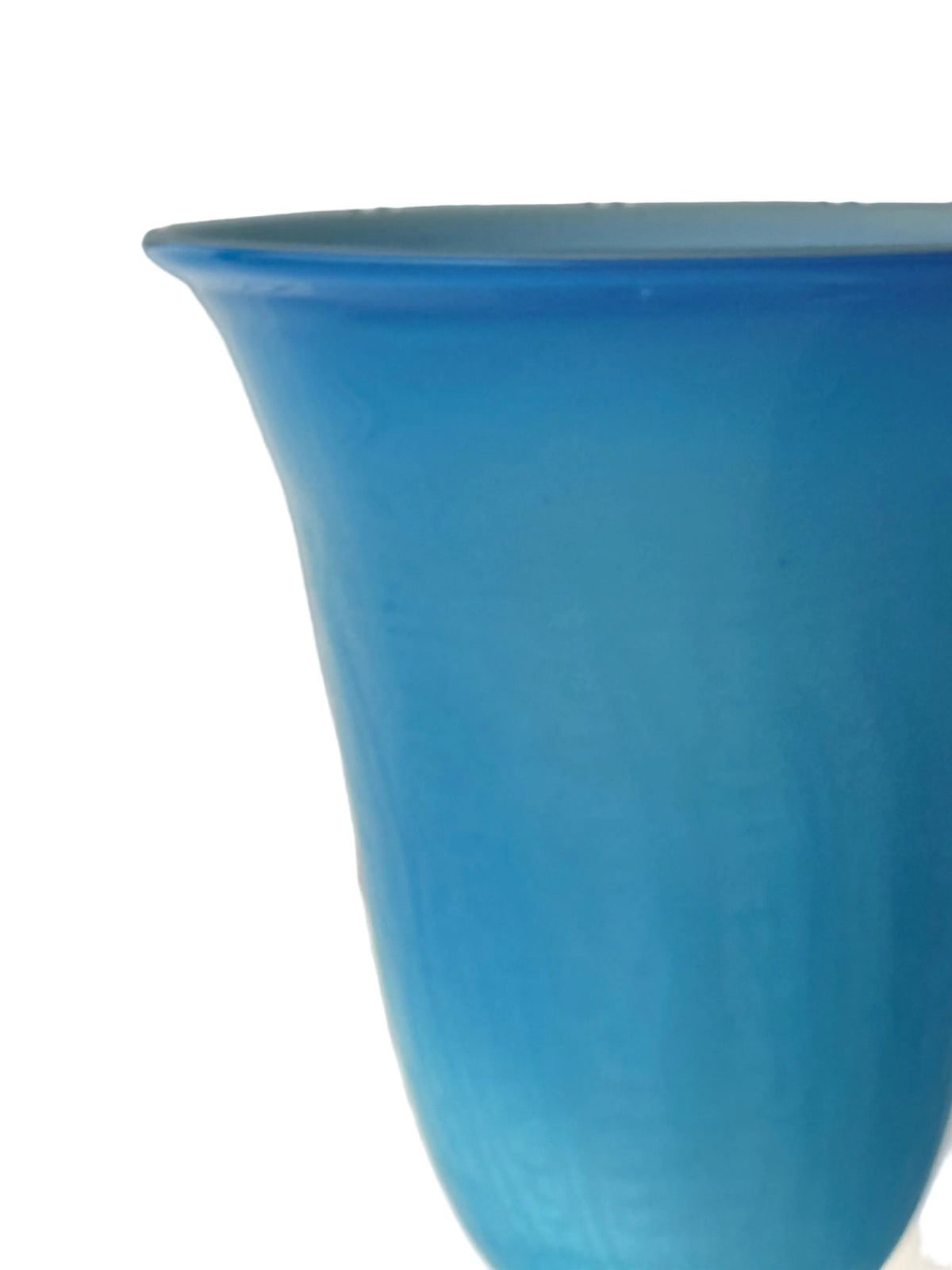 A close-up of a translucent blue glass vase or planter against a white paneled background.
