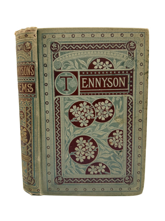 An antique hardcover book titled 'Tennyson' with ornate floral and geometric embossed decoration in muted green, burgundy, and tan tones, photographed upright against a plain light background.