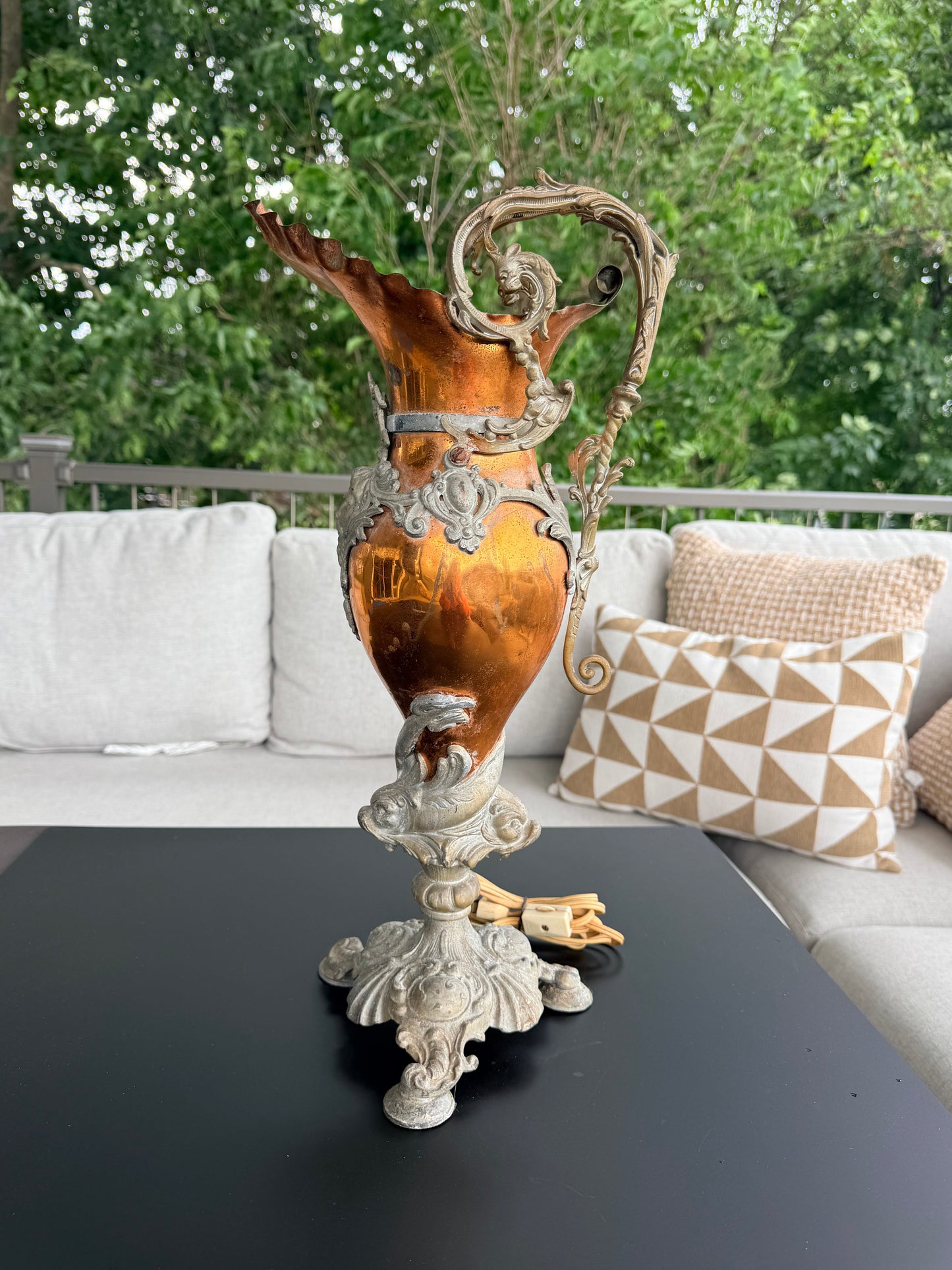 Decorative vase on a table with a blurred green outdoor background