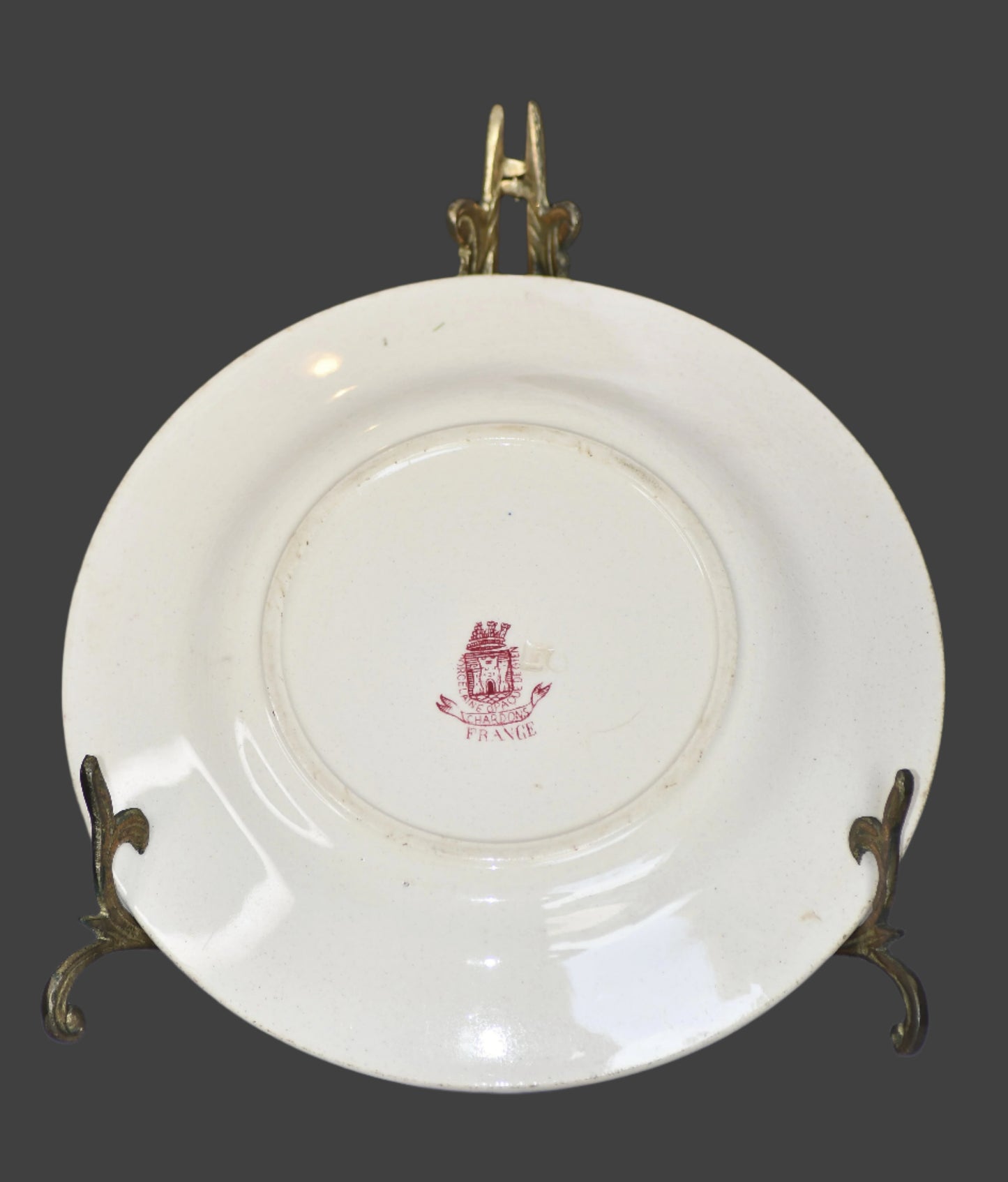 White plate with a red emblem on a stand, blurred background