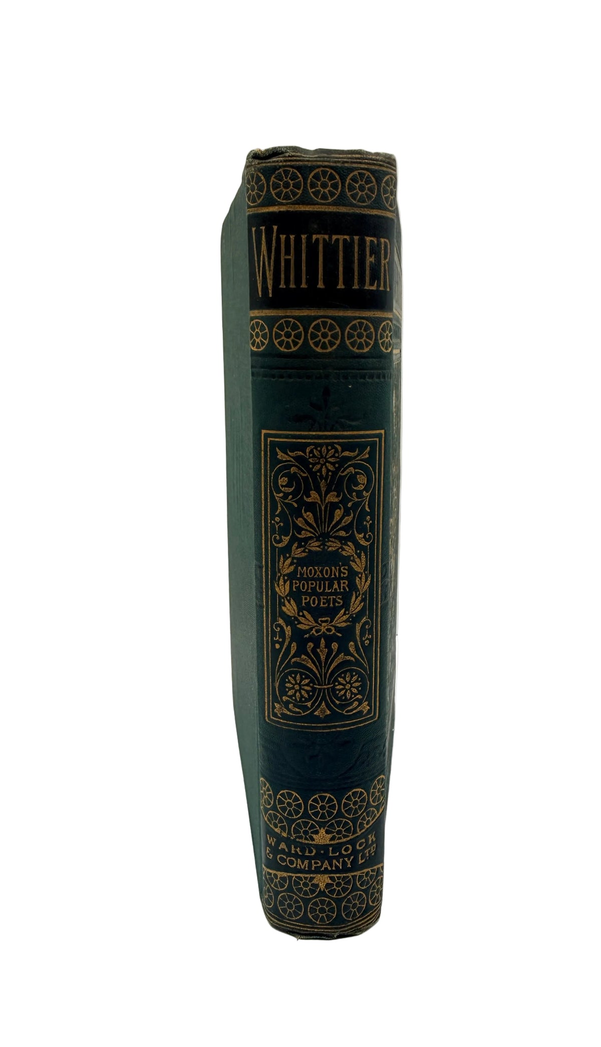 A vintage hardcover book standing upright, showing its dark green leather-bound spine with gold decorative lettering and ornamental border details. The title 'WHITTIER' is visible near the top.