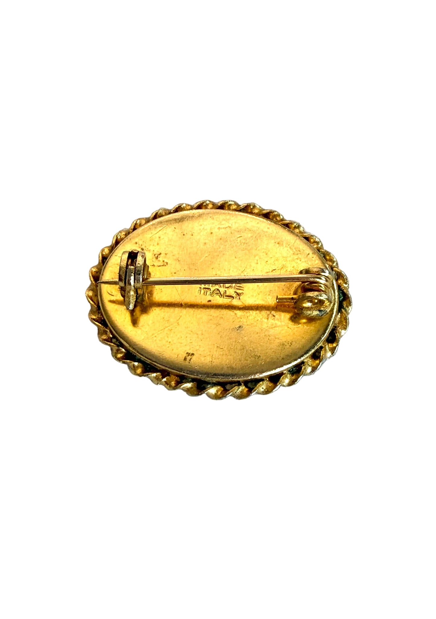 Gold brooch with 'ITALY' engraving on a light gray background