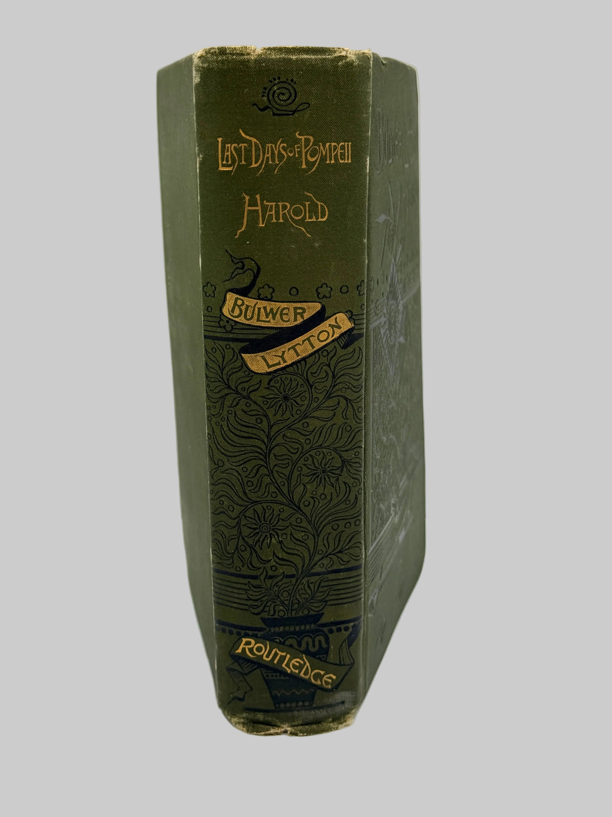 A vintage hardcover book, 'Last Days of Pompeii' by Harold Bulwer, published by Roundhead. The book features an olive green cloth spine with gold lettering and decorative floral engravings.