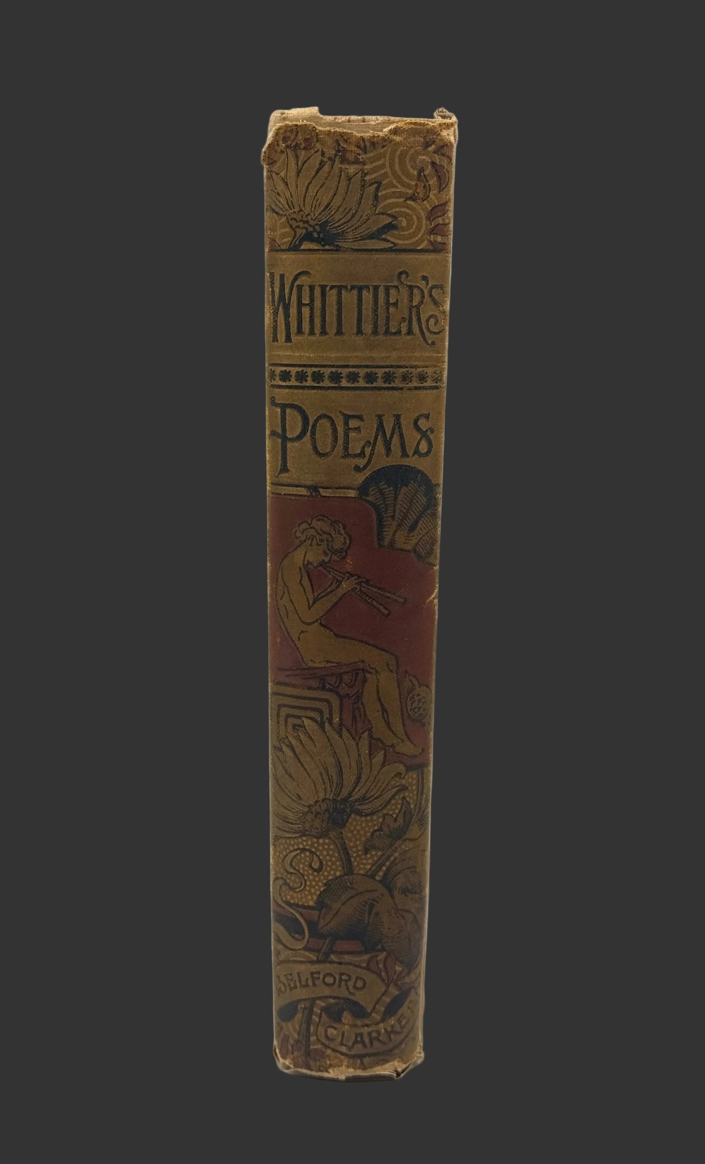 An antique book spine titled 'Whittier's Poems' with ornate gold and red decorative illustrations on a light gray background.
