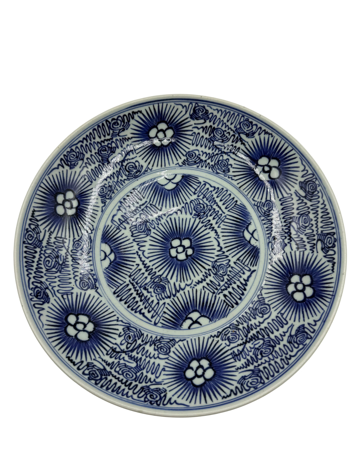 A round ceramic plate with an intricate blue and white floral pattern, photographed from directly above on a clean white background.