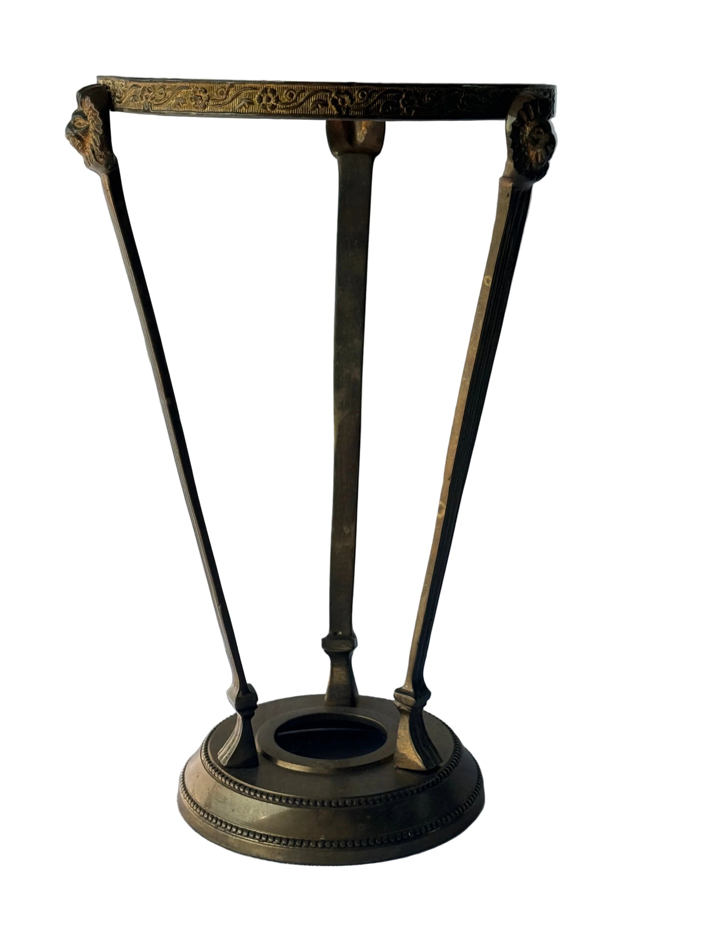 An antique-style bronze metal stand with a circular base, three angled legs, and an ornate top frame, photographed against a white paneled wall.