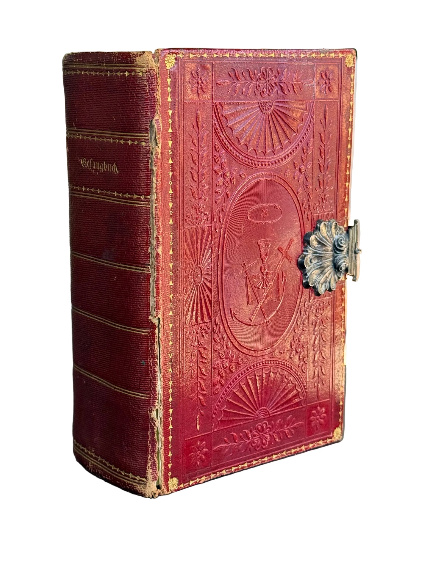 Antique red leather prayer book with intricate designs and closed clasp