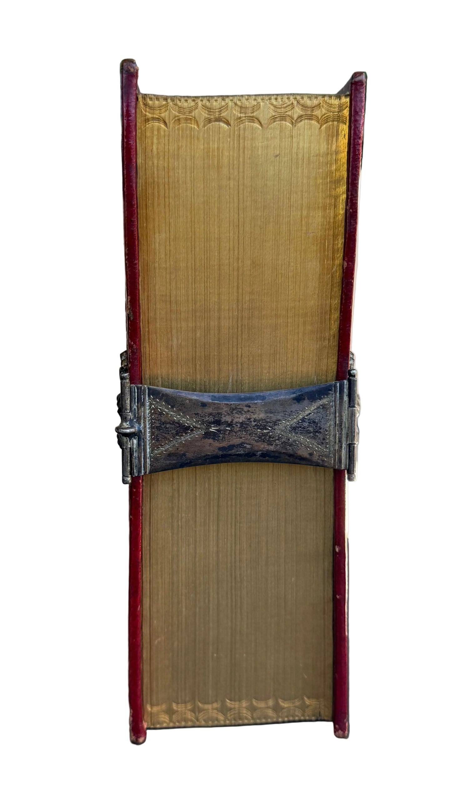 Decorative book with ornate cover and metal band on a surface outdoors.
