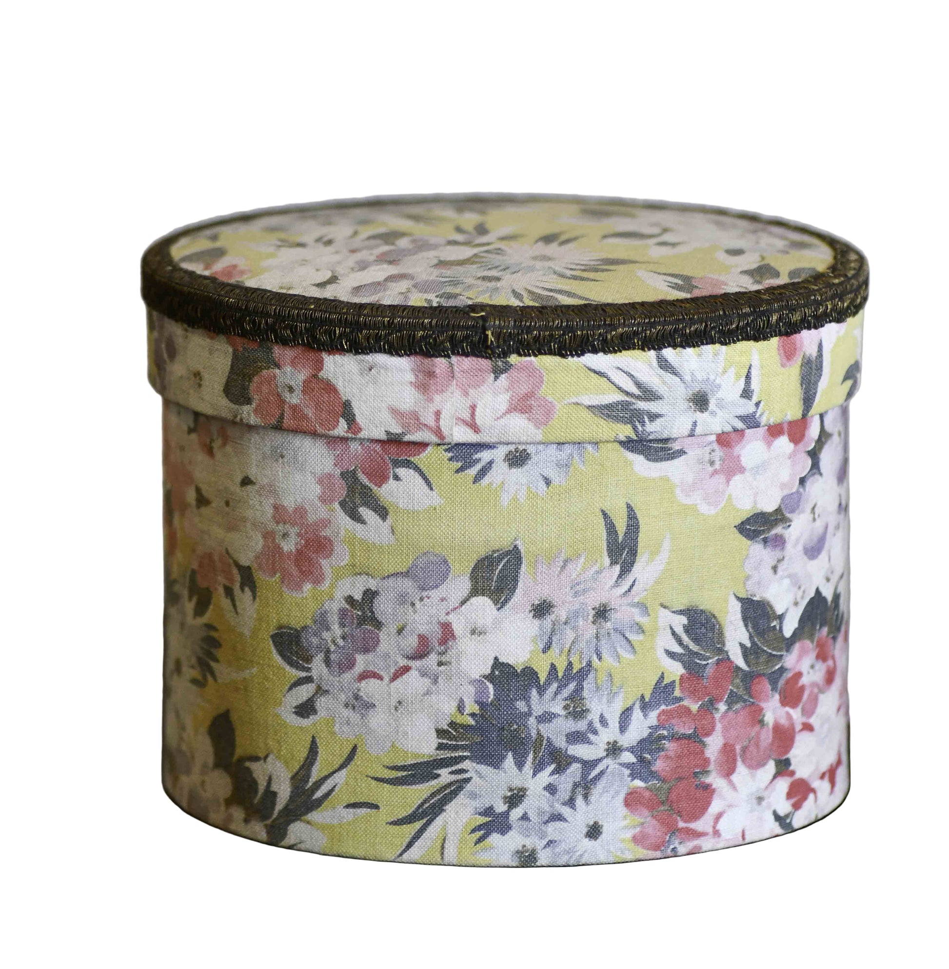 A vintage French boudoir cloth sewing box with a yellow background, featuring pink, blue, and purple flowers, and a bronze-colored lid edge.