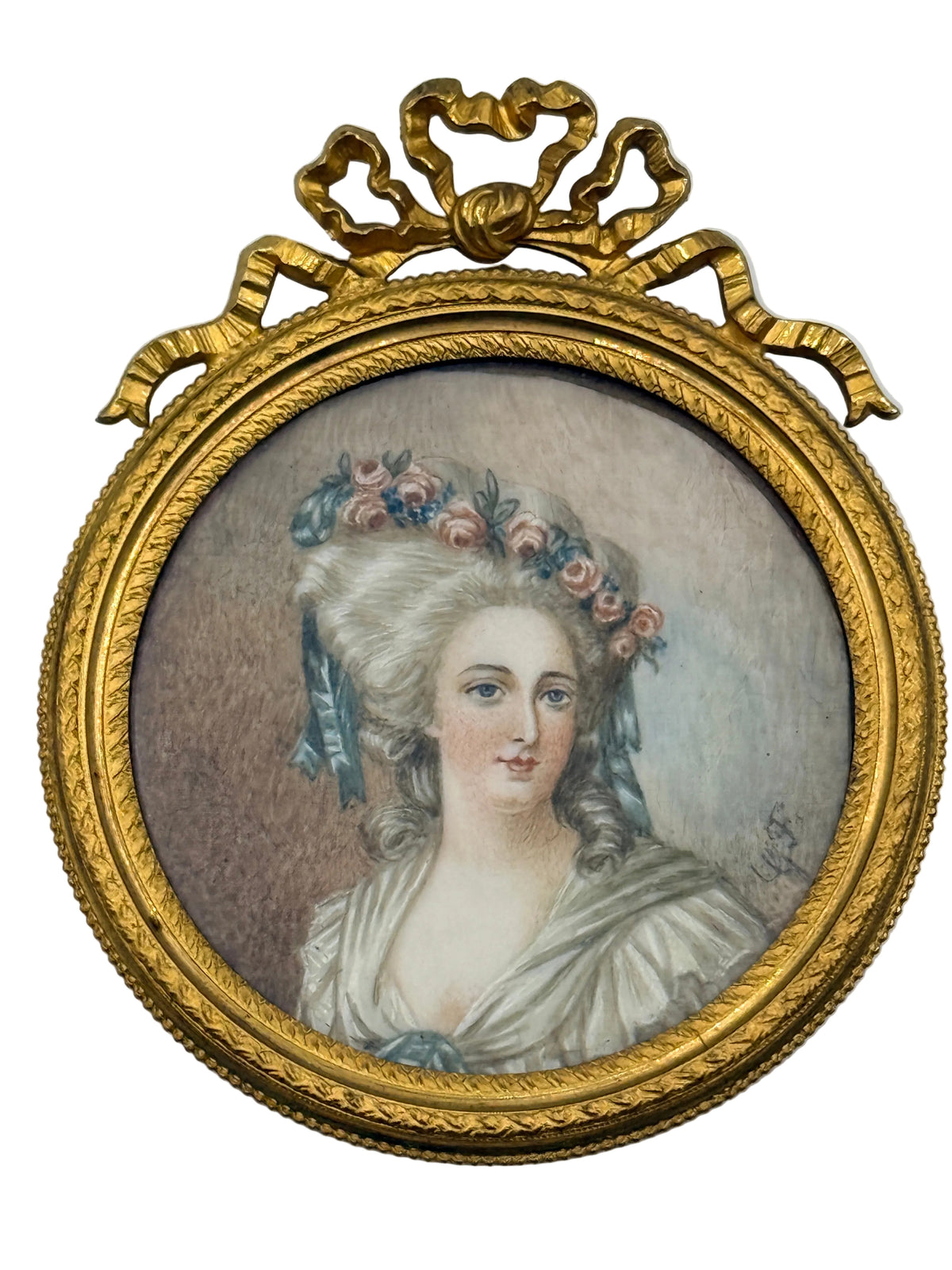 An oval framed portrait painting of a woman with a floral hairpiece, set in an ornate gold frame with a decorative top crest, shown against a plain light background.