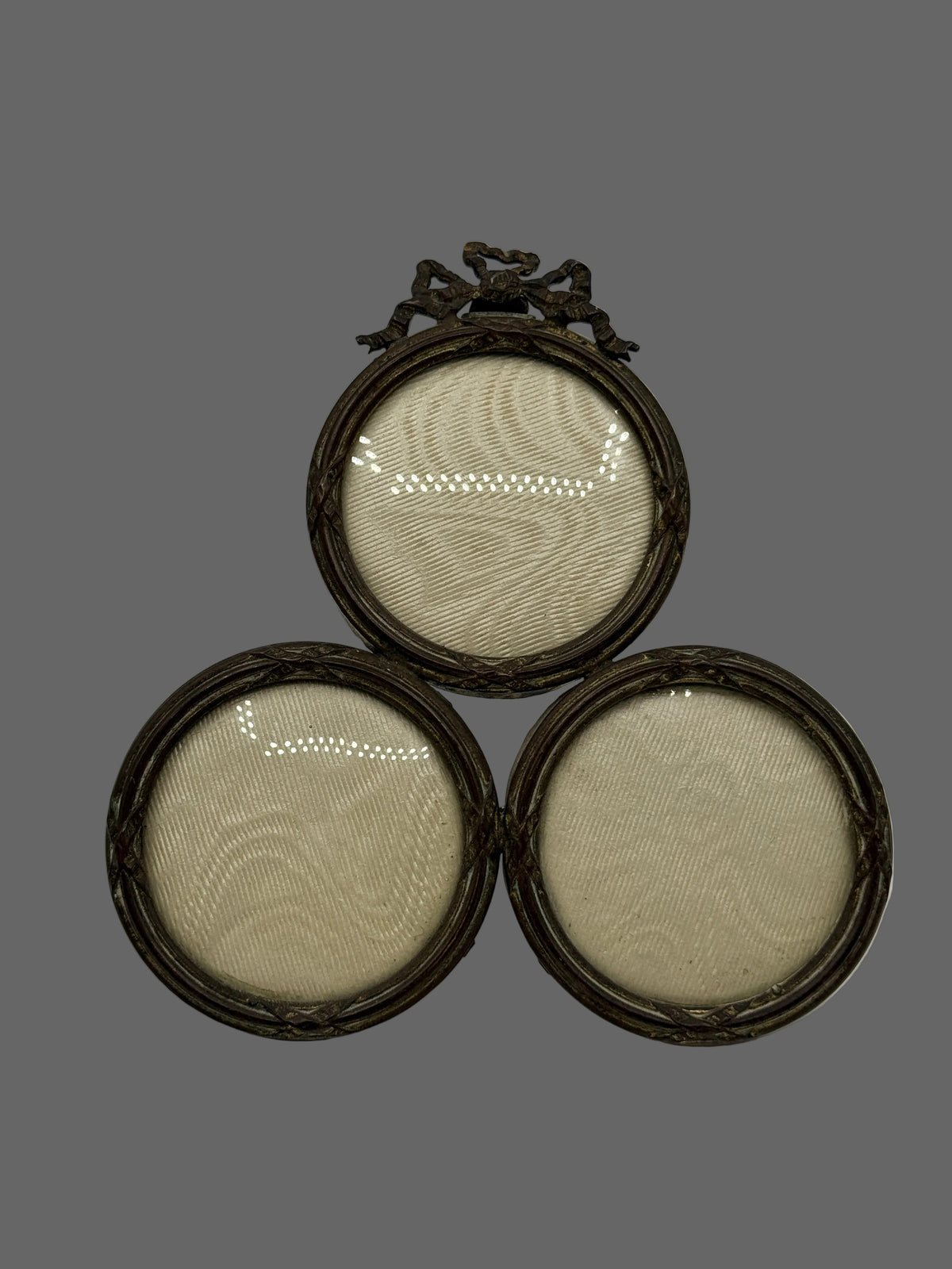 Three round vintage picture frames with dark brown woven frames and a decorative dark metal top piece, arranged in a pyramid on a light gray background.