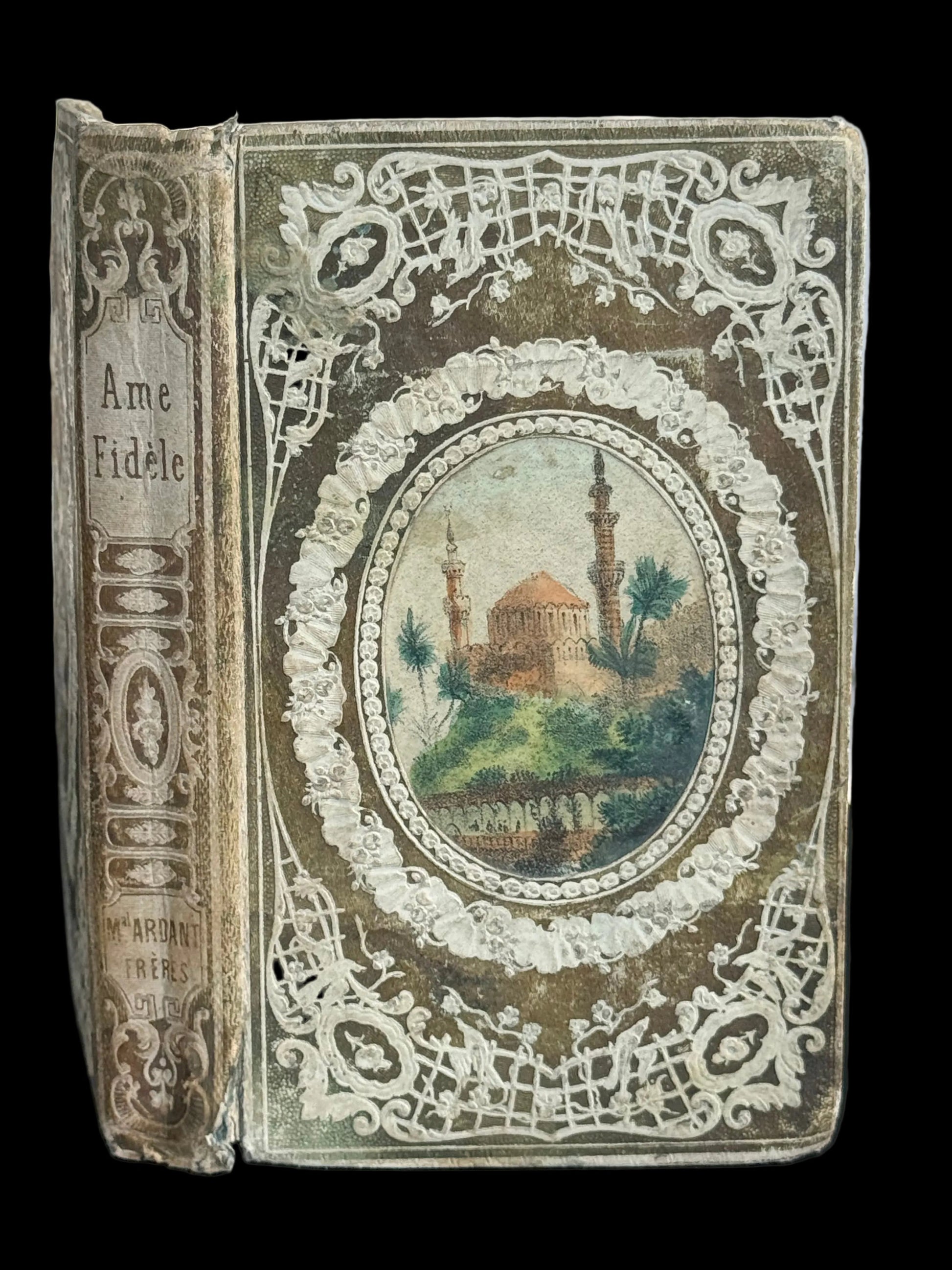 Decorative book with intricate design and central illustration on a plain background