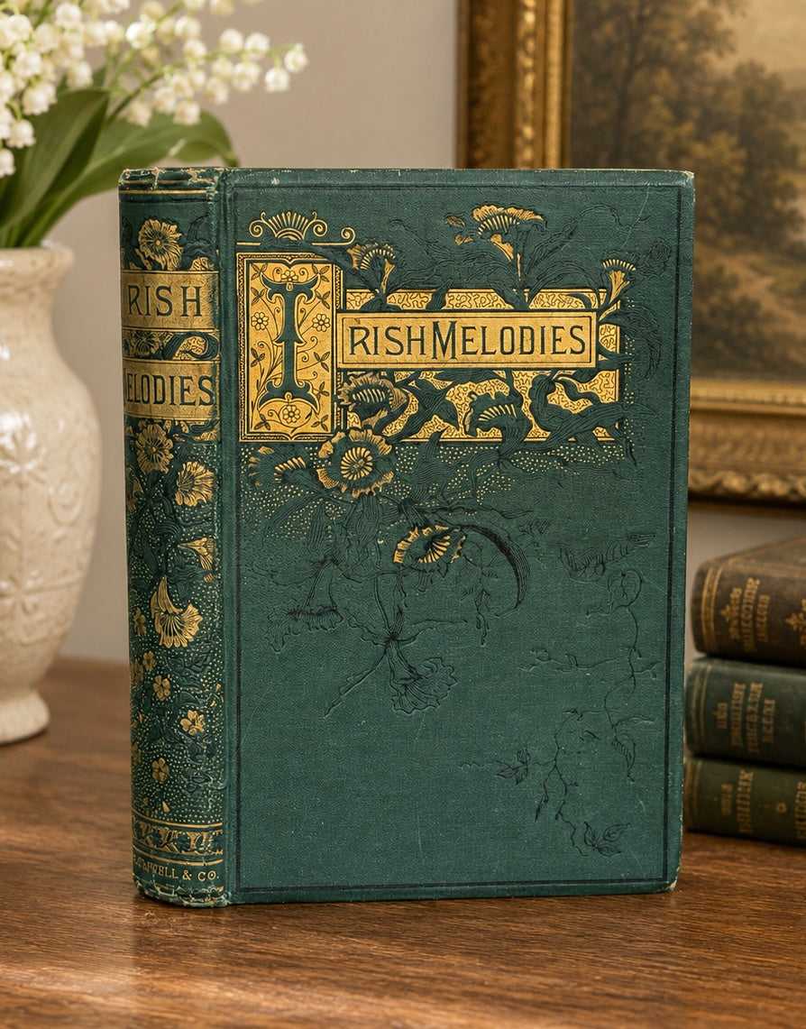 Vintage book titled 'Irish Melodies' with decorative cover on a wooden surface.