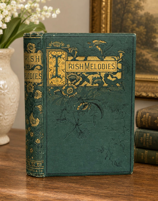 Vintage book titled 'Irish Melodies' with decorative cover on a wooden surface.