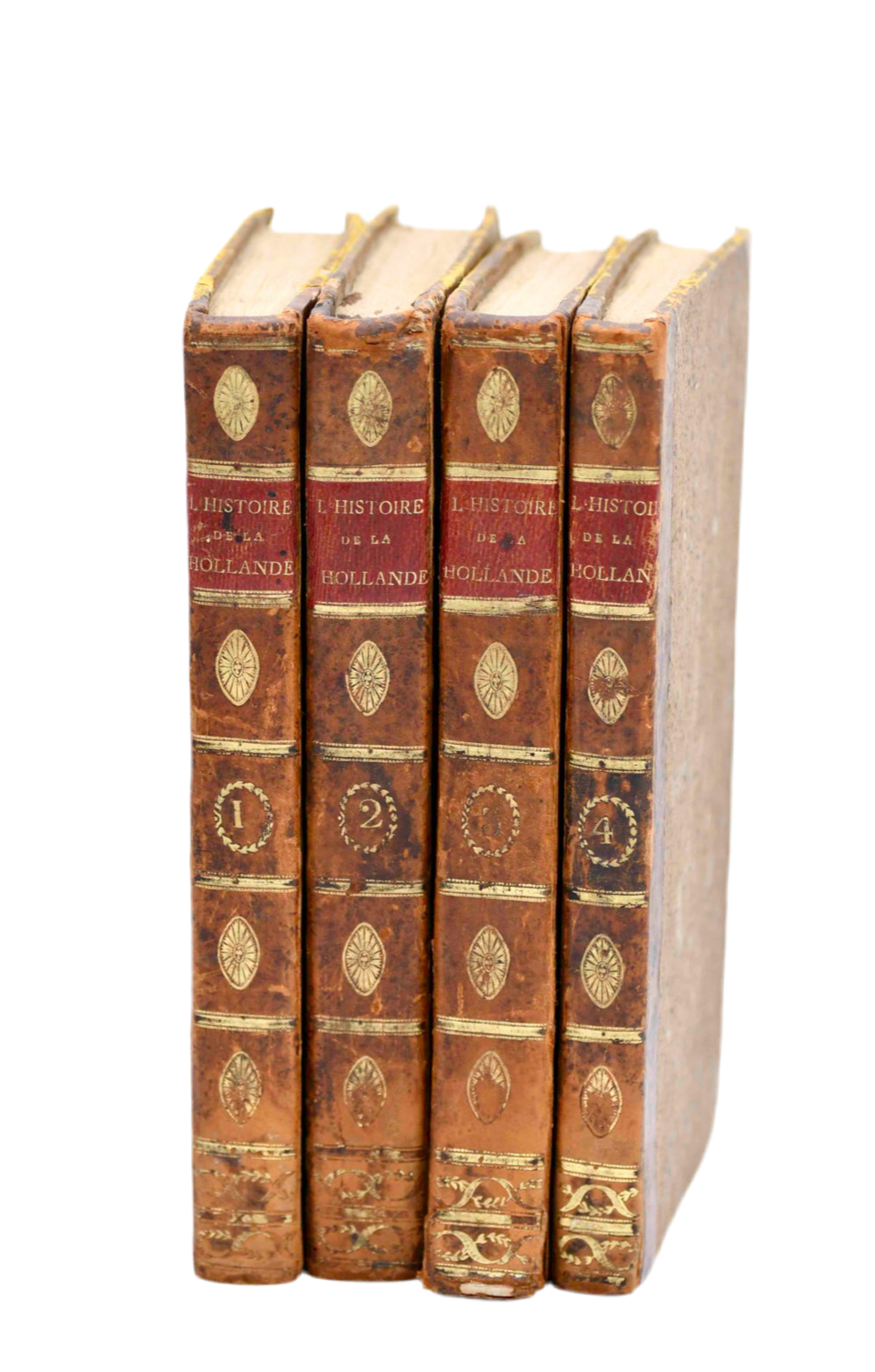 Set of four ornate books with decorative spines on a white background