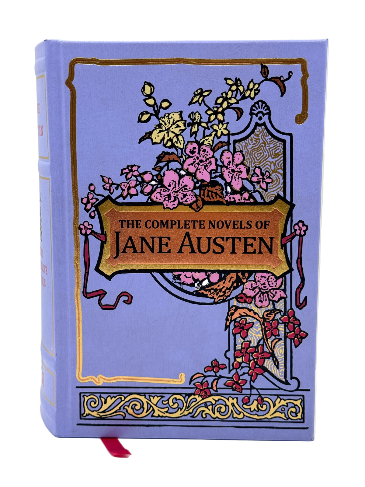A hardcover book of Jane Austen's novels with a lavender-purple cover, decorated with pink flowers, gold borders, and a gold title banner reading 'The Complete Novels of Jane Austen'. A red ribbon bookmark is visible at the bottom.
