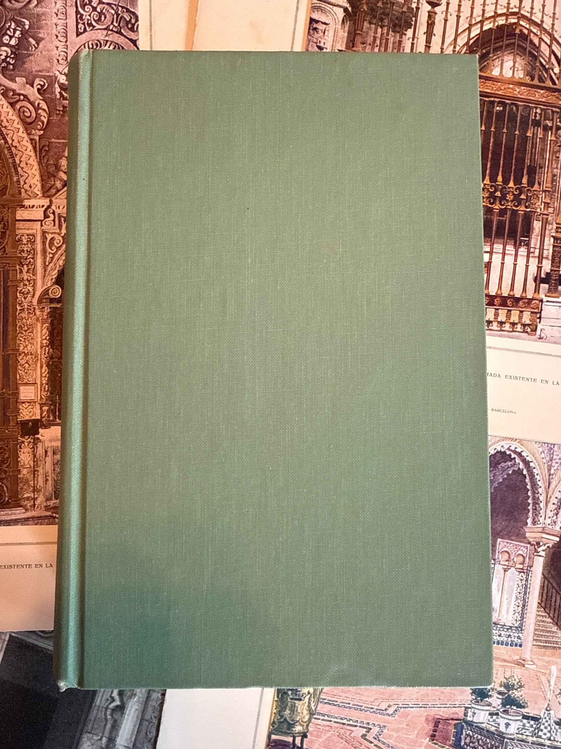Green book on a textured surface with architectural design