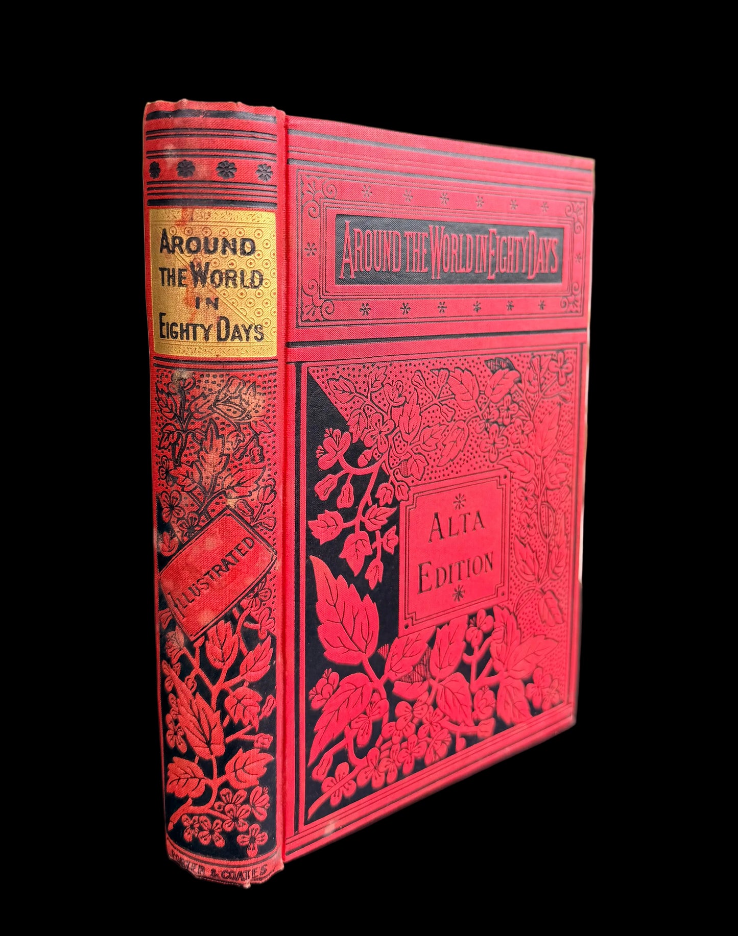 Red book titled 'Around the World in Eighty Days' on a black surface with a blurred outdoor background