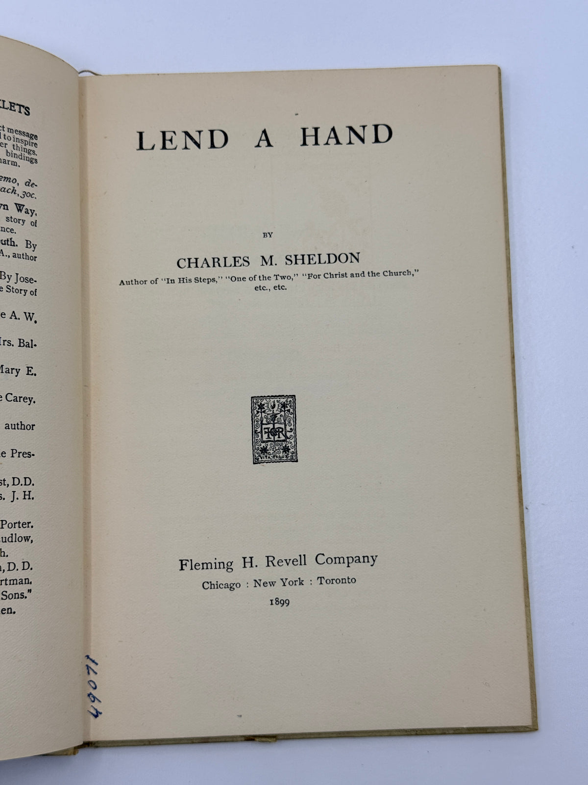 An open vintage book showing the title page for 'Lend a Hand' by Charles M. Sheldon, published by Fleming H.
