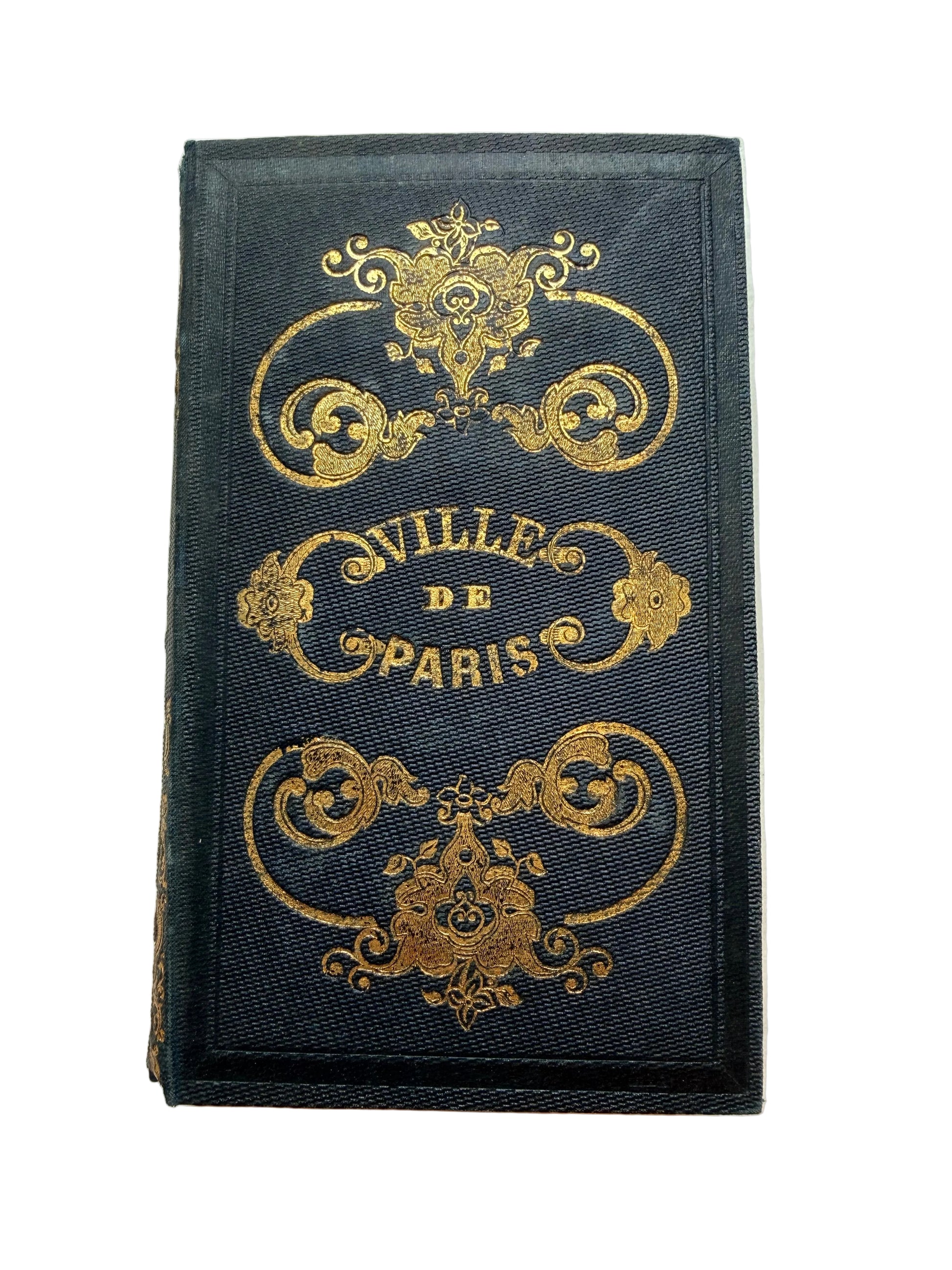 Decorative black book with gold text and designs on a marble surface