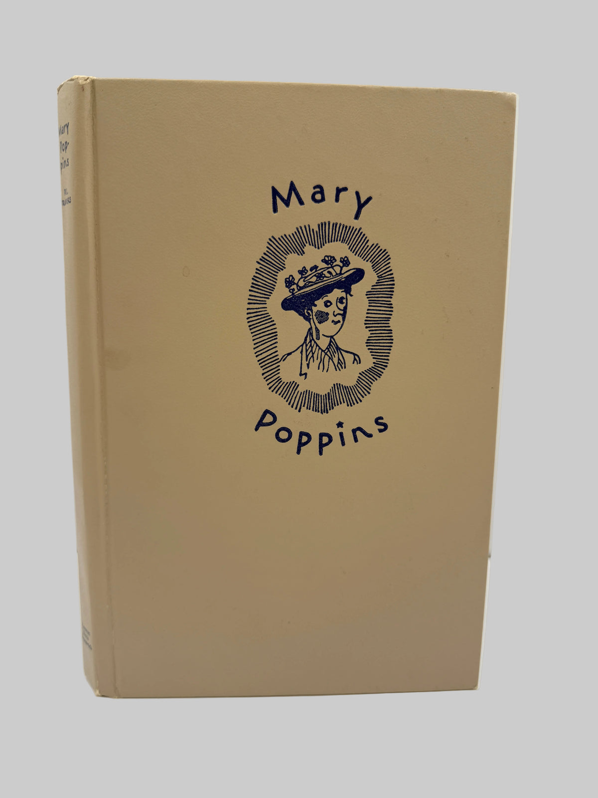 A vintage hardcover book of Mary Poppins with a tan cover and a dark blue illustration of the character on the front, set against a plain white background.