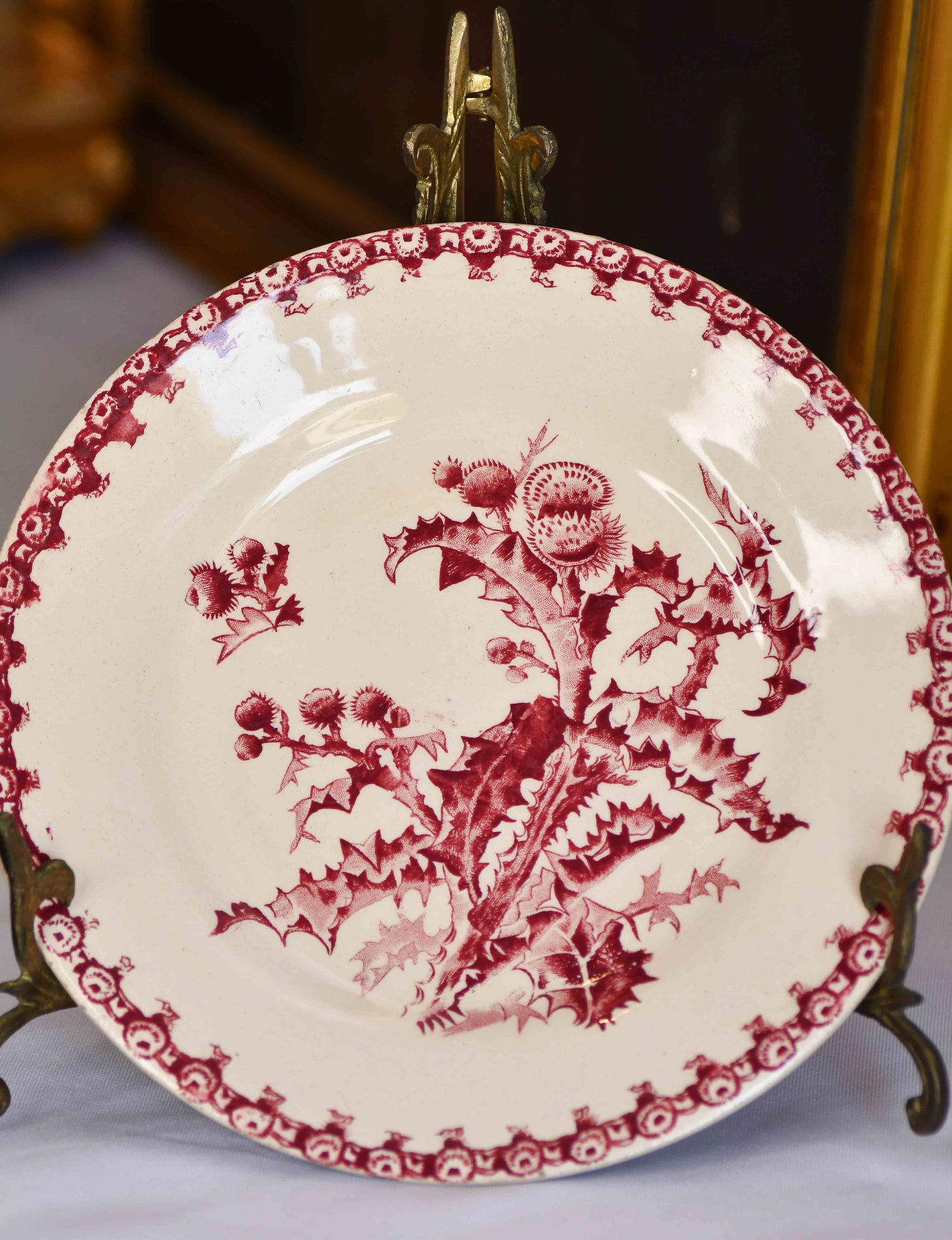 Decorative plate with red floral pattern on a stand.