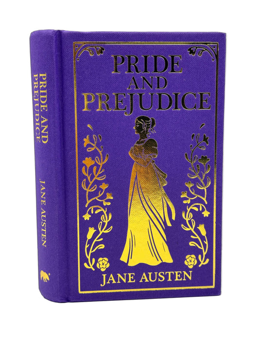 A hardcover edition of Jane Austen's 'Pride and Prejudice' featuring a deep purple cloth cover with metallic gold foil detailing, including the title, author name, and a central silhouette of a woman in a gown.