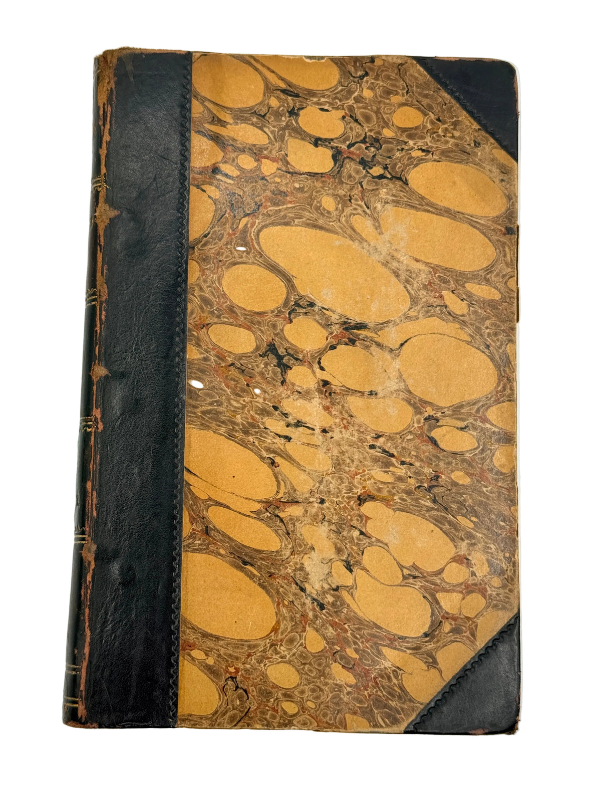 An antique hardcover notebook or journal featuring a marbled tan and brown paper cover with black leather corner protectors and a black leather spine band.