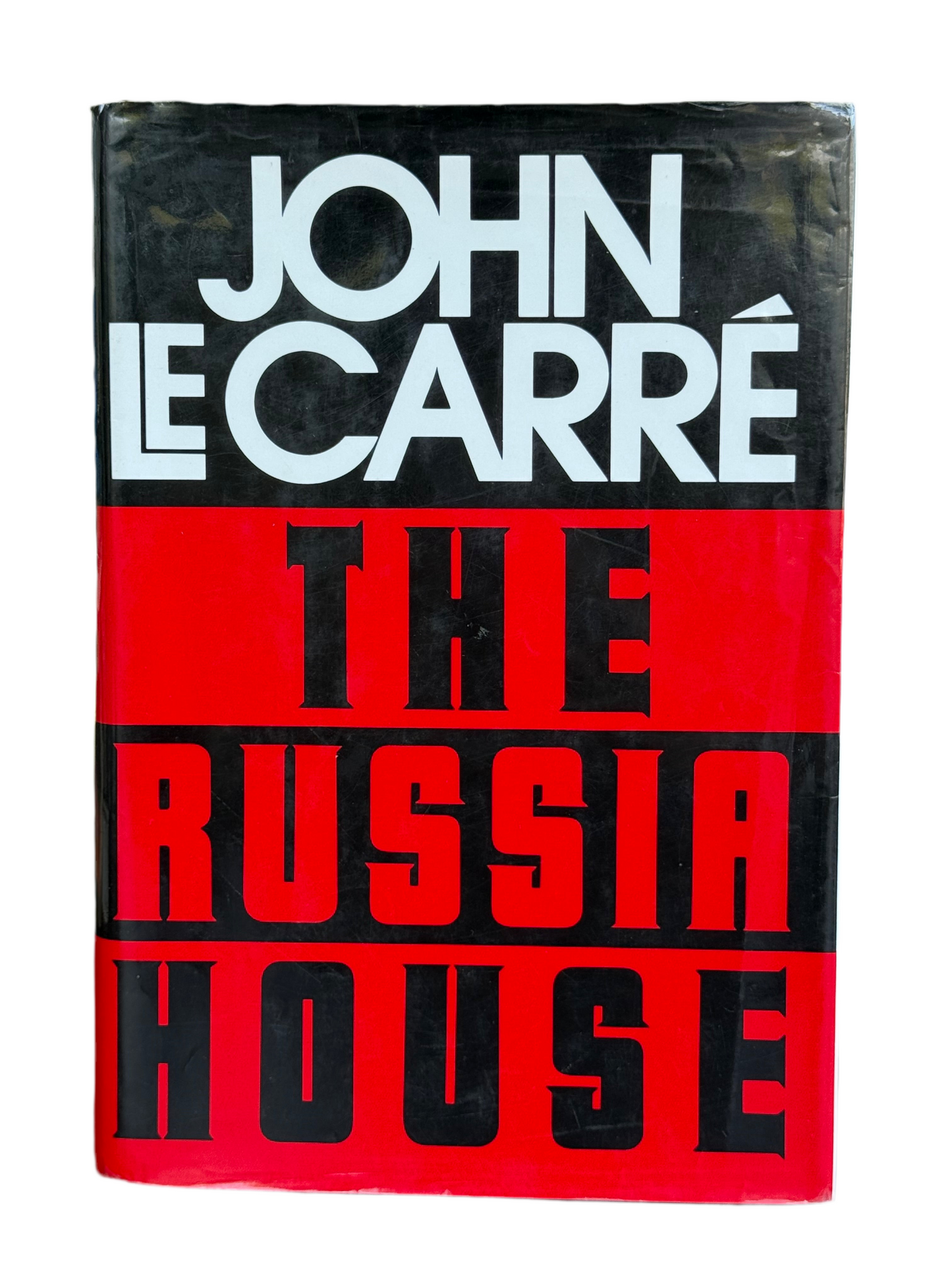 Book cover of 'The Russia House' by John Le Carre with a black and red design.