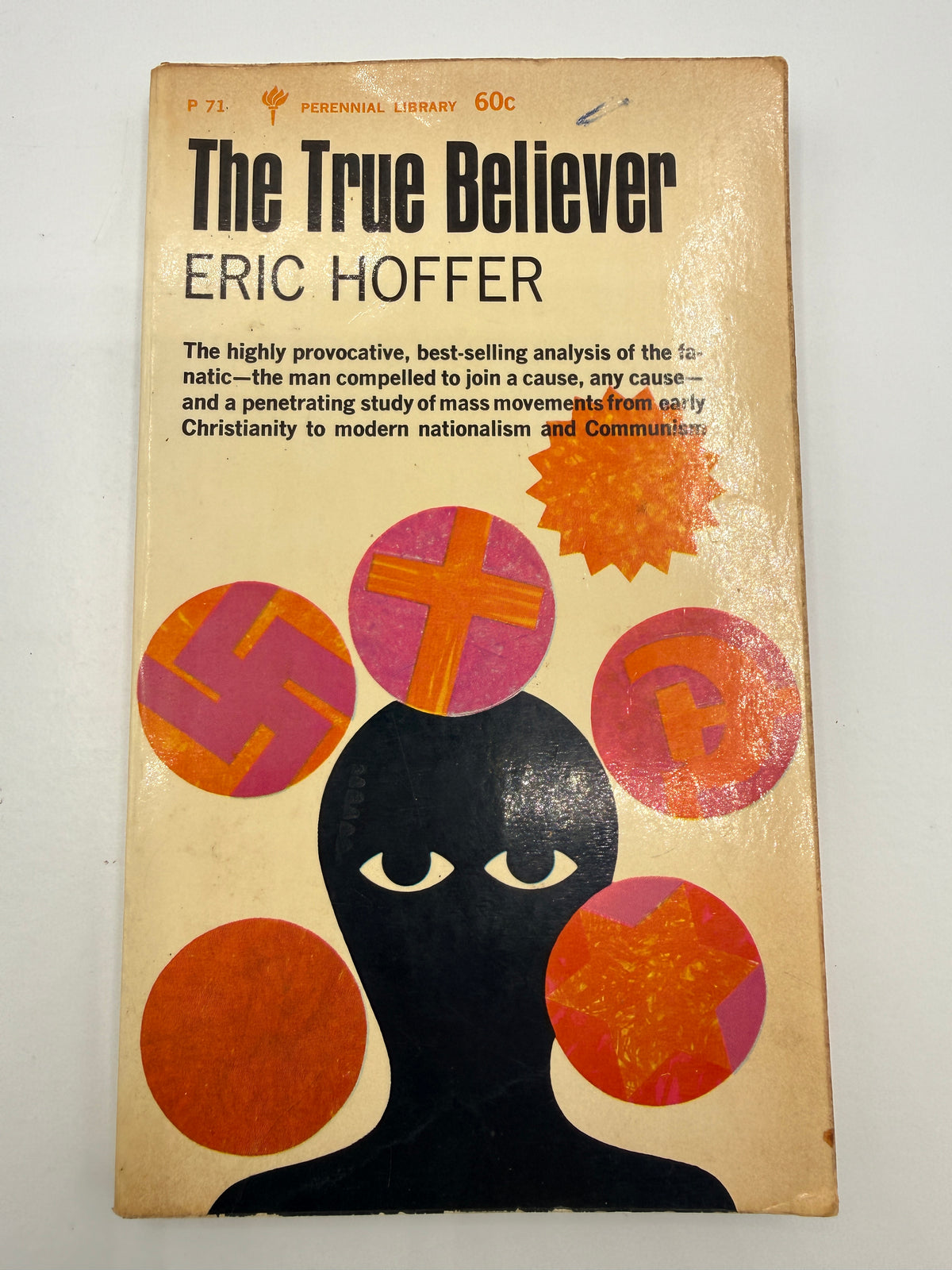 Vintage paperback book cover of 'The True Believer' by Eric Hoffer, featuring a beige background with bold black title text and abstract pink, orange, and black graphic elements.