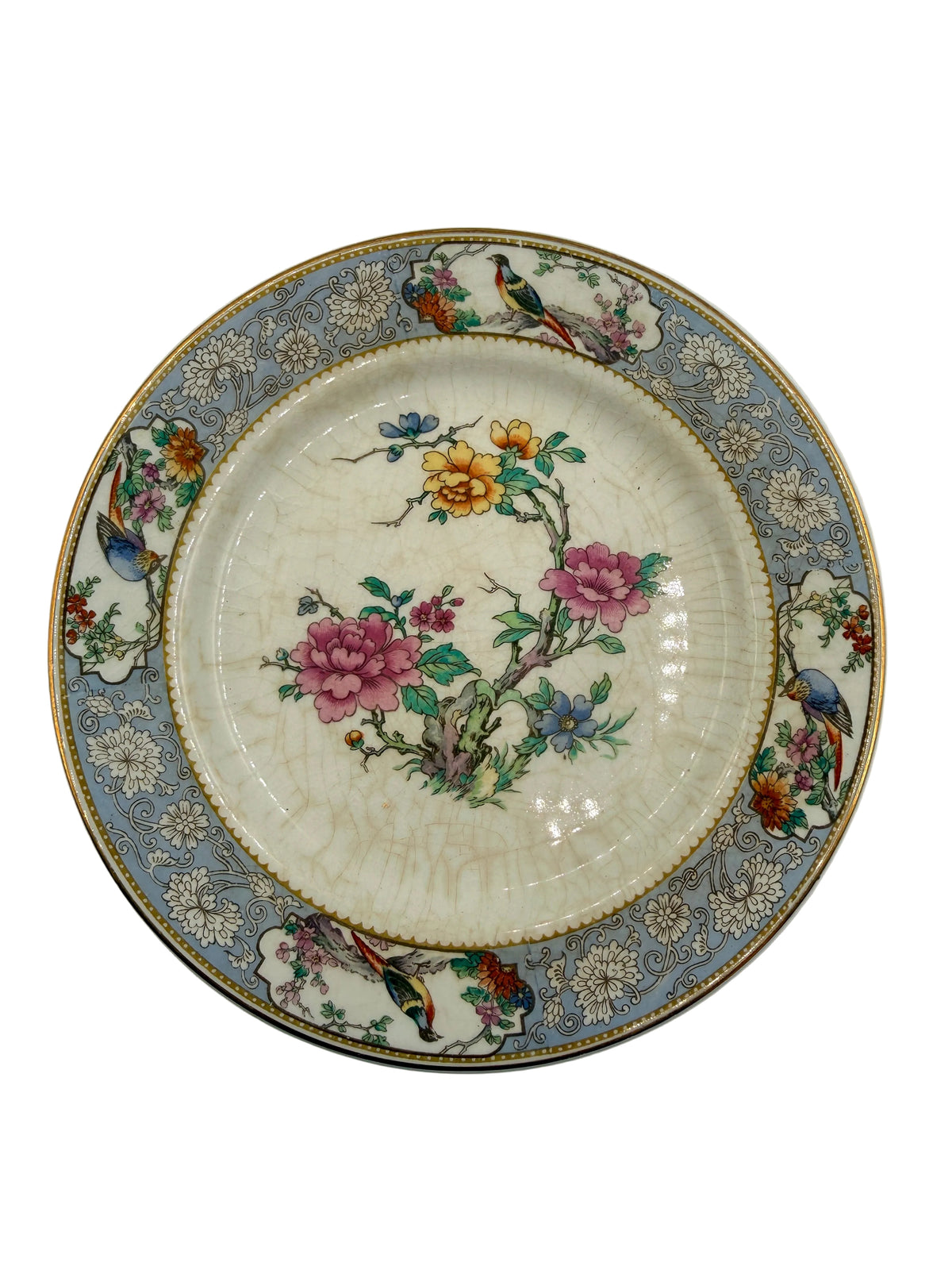 An antique ceramic plate featuring a floral and bird pattern, with a cream-colored center, a blue-gray border, and gold accents.