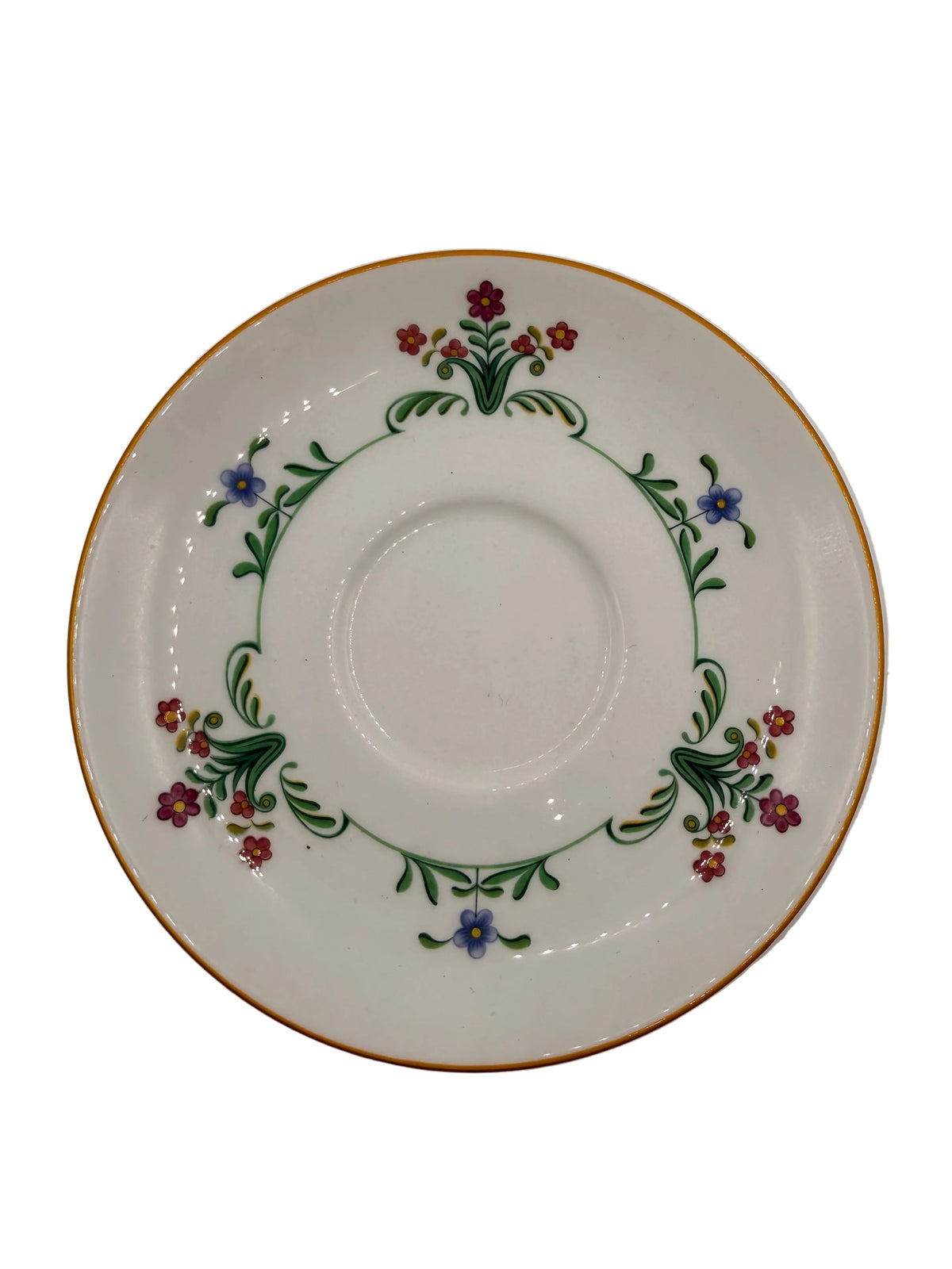 A white porcelain saucer decorated with a delicate floral border featuring green leaves, red and purple flowers, and a thin gold rim, shown on a plain light gray background.
