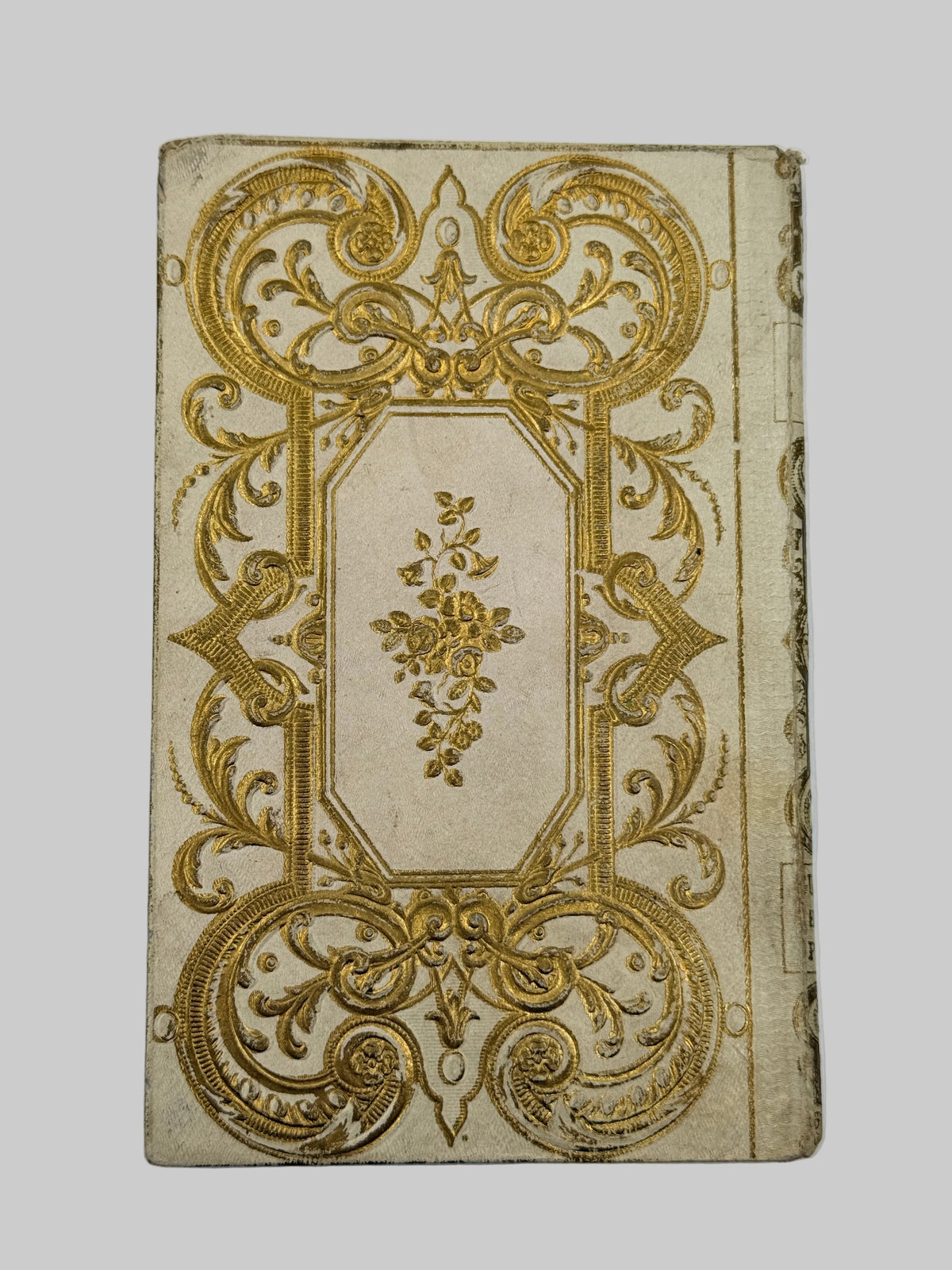 An antique rectangular paper card or label featuring an ornate gold embossed filigree border and central floral motif on a cream-colored background, shown against a plain white backdrop.