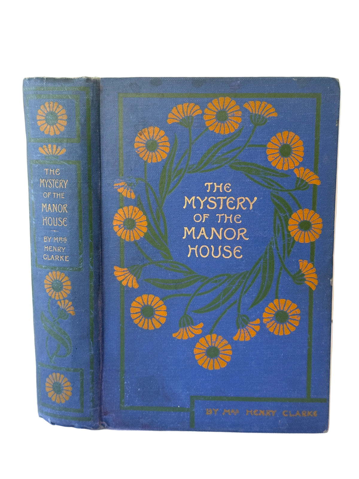 Vintage hardcover book titled 'The Mystery of the Manor House' by Mary Elizabeth Clarke, featuring a blue cover with yellow daisy illustrations and gold lettering, photographed on a light background.