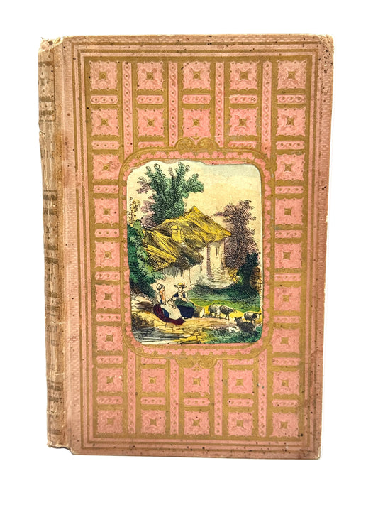An antique hardcover book with a pink and gold geometric patterned cover, featuring a central rectangular illustration of a pastoral landscape with figures and animals.