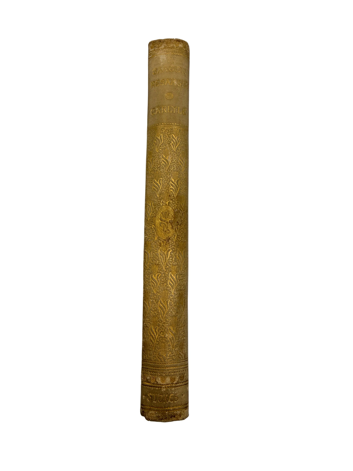 A close-up of a vintage book's gold-embossed spine against a plain light gray background.