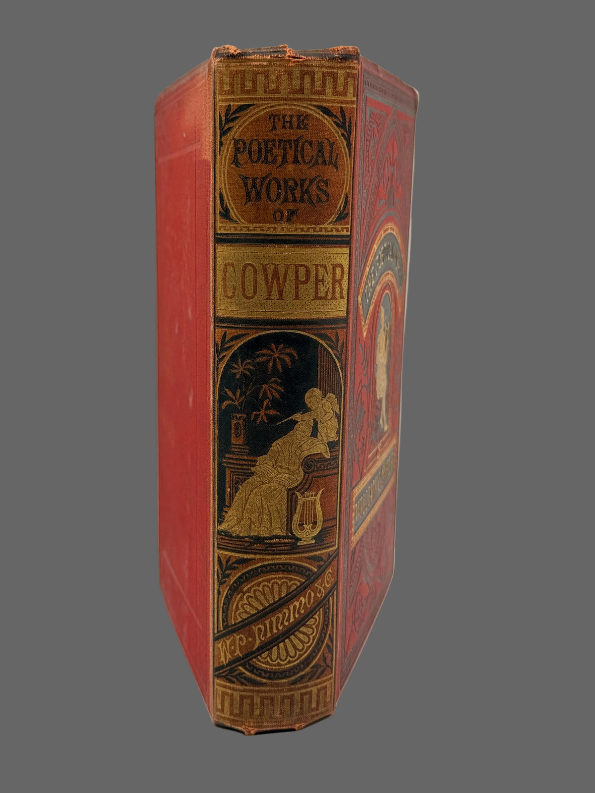A vintage octagonal hardcover book titled 'The Poetical Works of Cowper' with a red cloth binding and ornate gold and black gilded decorative panels on the spine and cover.